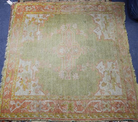 An Antique Turkestan square mat, with central green and red medallion, 108 x 121cm